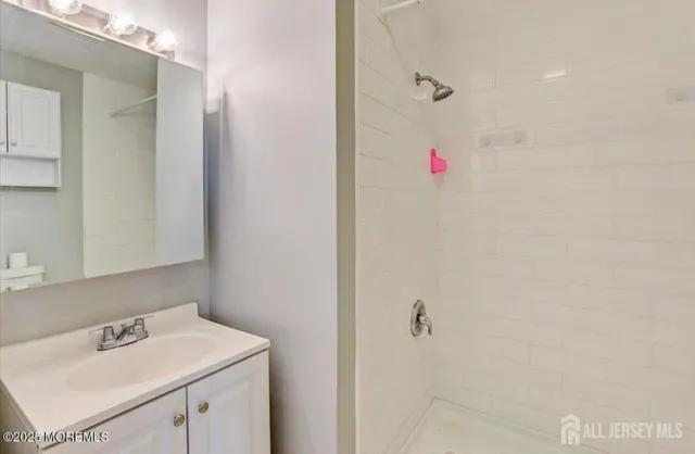 a bathroom with a sink vanity and tub