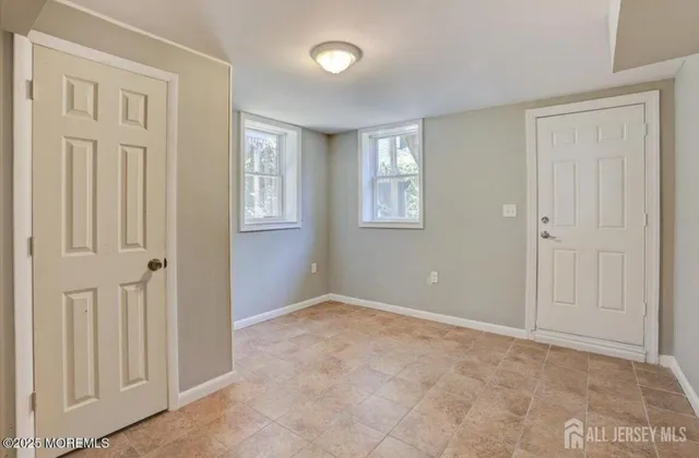a view of an empty room with windows and closet area