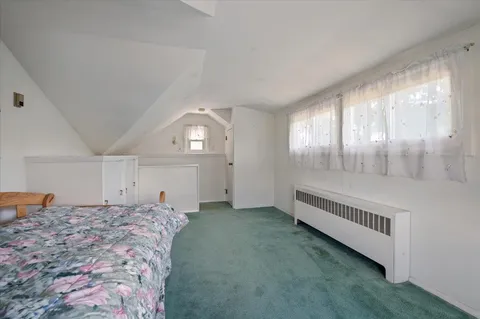 a spacious bedroom with a bed and a window