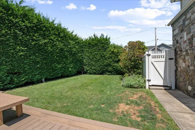 a view of a street with potted plants and brick walls
