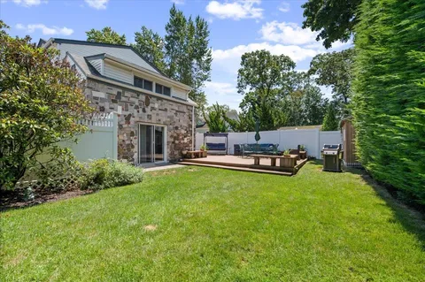 a backyard of a house with table and chairs and a fire pit