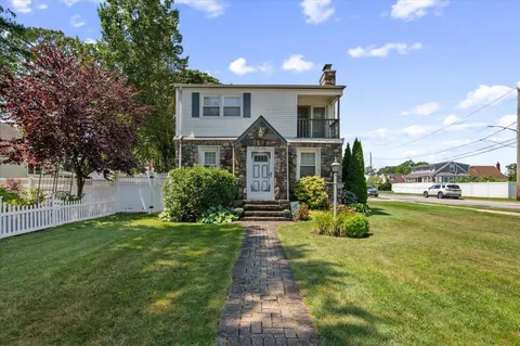 a front view of a house with a garden and yard