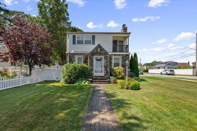 a front view of a house with a garden and yard