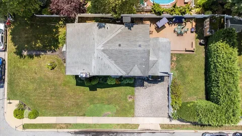 an aerial view of a house with a yard and large trees