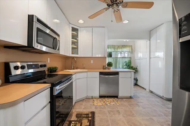 a kitchen with stainless steel appliances granite countertop a sink and a stove top oven