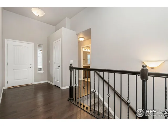 a view of a hallway with wooden floor and stairs