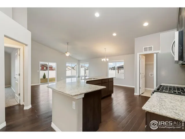 a open kitchen with kitchen island a sink dishwasher a refrigerator and a stove with wooden floor