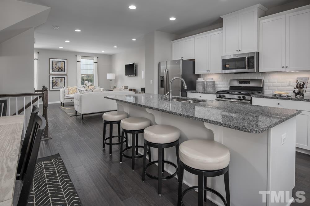 6605 Pathfinder Way Raleigh, NC 27616 - Photo 1 of 3 a kitchen with stainless steel appliances granite countertop a dining table chairs microwave and sink