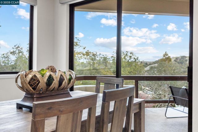 a view of a dining room with furniture large windows and wooden floor