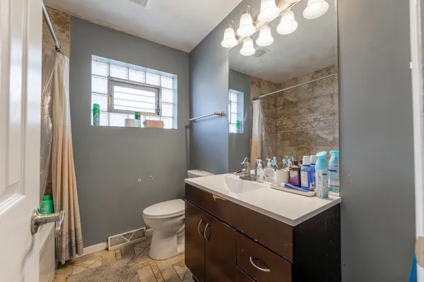 a bathroom with a sink a toilet and a mirror