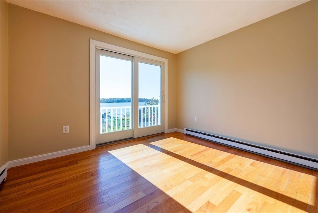 62 Eastern Point Road, Unit 3 Gloucester, MA 01930 - Photo 20 of 27 a view of an empty room with wooden floor and a window
