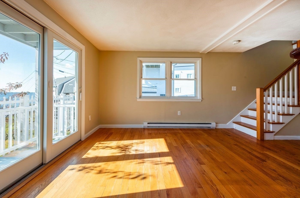 62 Eastern Point Road, Unit 3 Gloucester, MA 01930 - Photo 9 of 27 a view of an empty room with wooden floor and a window
