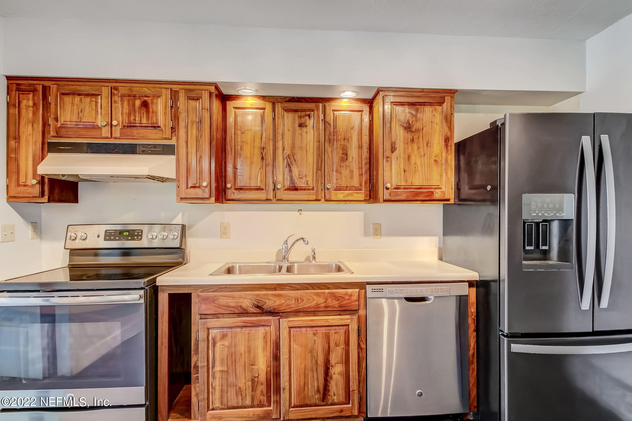 75055 Edwards Road Yulee, FL 32097 - Photo 8 of 34 a kitchen with stainless steel appliances granite countertop a refrigerator sink and stove