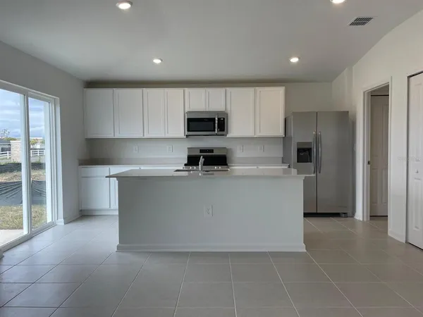 a large kitchen with cabinets and a refrigerator
