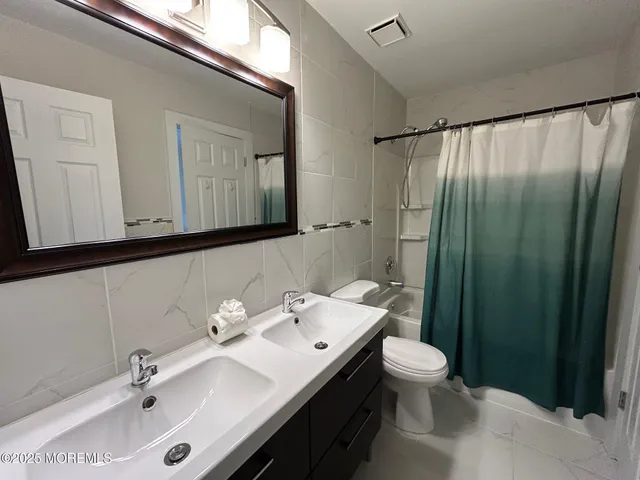 a bathroom with a sink a toilet and mirror