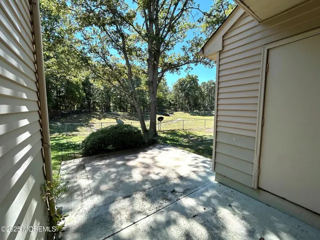 a view of a yard with large trees and a barn in it