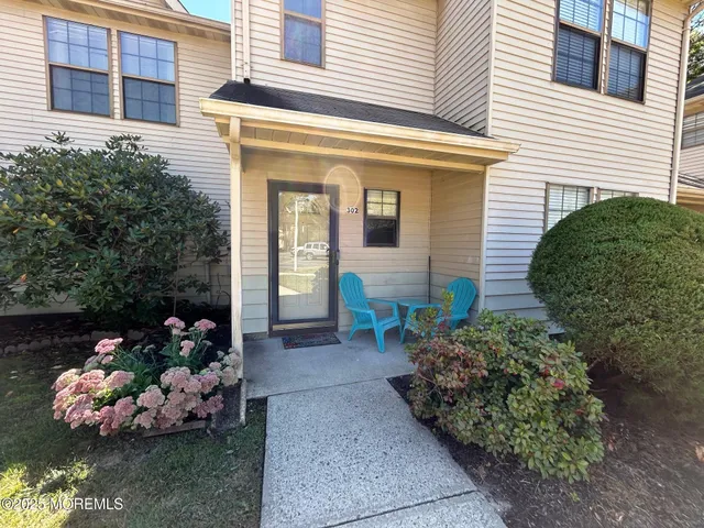 a front view of a house with a yard and potted plants