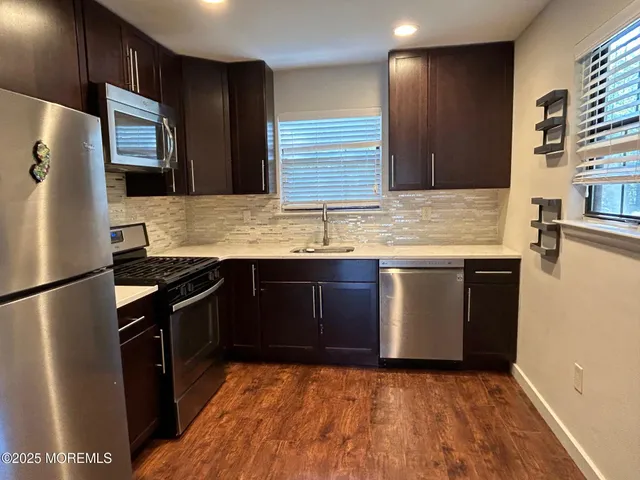 a kitchen with stainless steel appliances granite countertop a stove a refrigerator and a sink