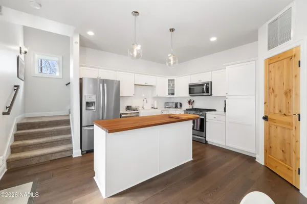 a kitchen with stainless steel appliances a refrigerator and a stove top oven