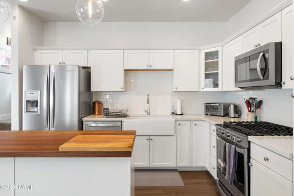 a kitchen with stainless steel appliances granite countertop a refrigerator a stove and a sink