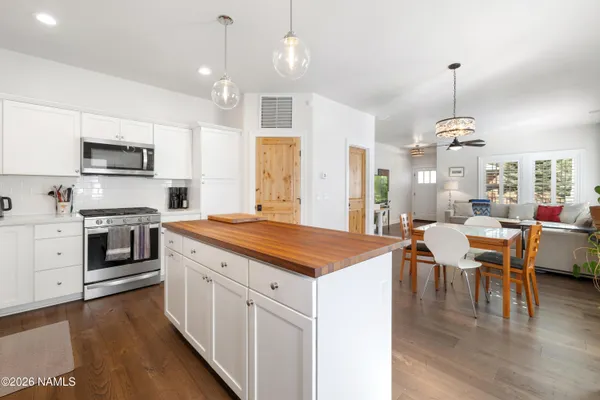 a kitchen with kitchen island granite countertop a sink a counter top space appliances and cabinets