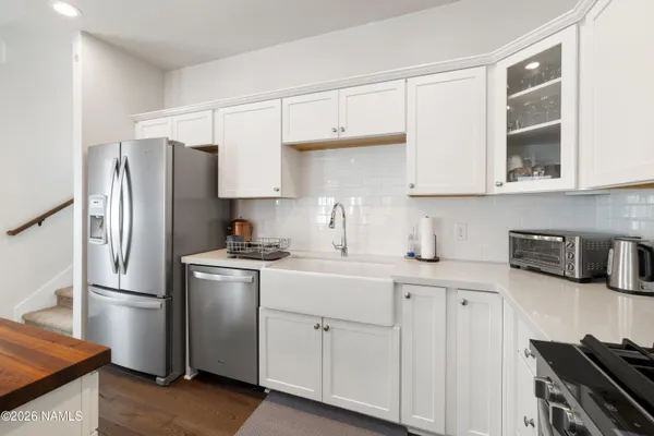 a kitchen with stainless steel appliances granite countertop a refrigerator sink and stove