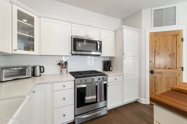 a kitchen with stainless steel appliances granite countertop a stove a sink and a microwave