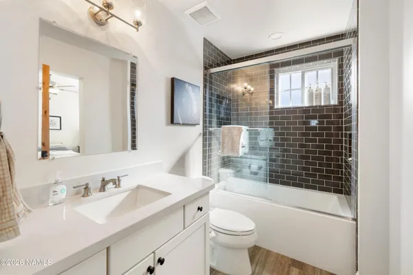 a bathroom with a sink toilet vanity and shower