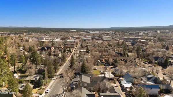 an aerial view of residential houses with outdoor space and trees