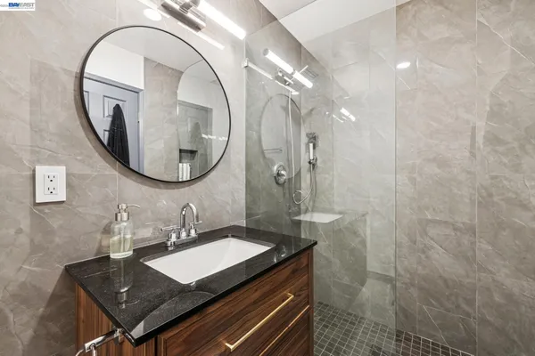 a bathroom with a sink a mirror and a shower