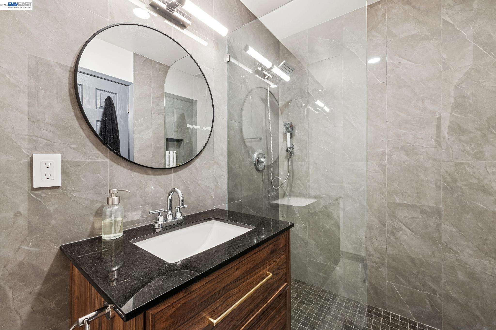 1321 Webster Street, Unit D116 Alameda, CA 94501 - Photo 6 of 22 a bathroom with a sink a mirror and a shower