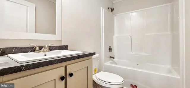 a bathroom with a sink a toilet a mirror a bathtub and shower