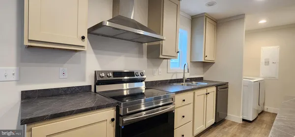 a kitchen with stainless steel appliances granite countertop white cabinets and a stove