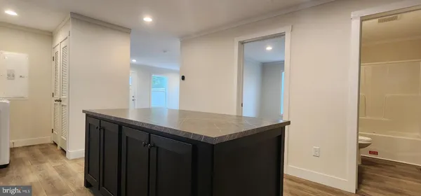 a bathroom with a granite countertop sink a mirror and shower
