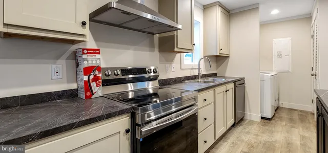 a kitchen with stainless steel appliances granite countertop a sink stove and cabinets