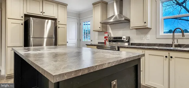 a kitchen with stainless steel appliances granite countertop a sink dishwasher stove and refrigerator with wooden floor