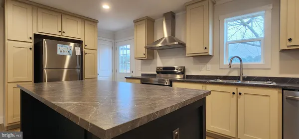 a kitchen with stainless steel appliances granite countertop a sink a stove and center island
