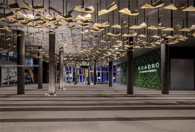 a living room with stainless steel appliances furniture and a kitchen view