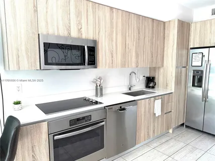 a kitchen with stainless steel appliances a sink a stove a microwave and cabinets