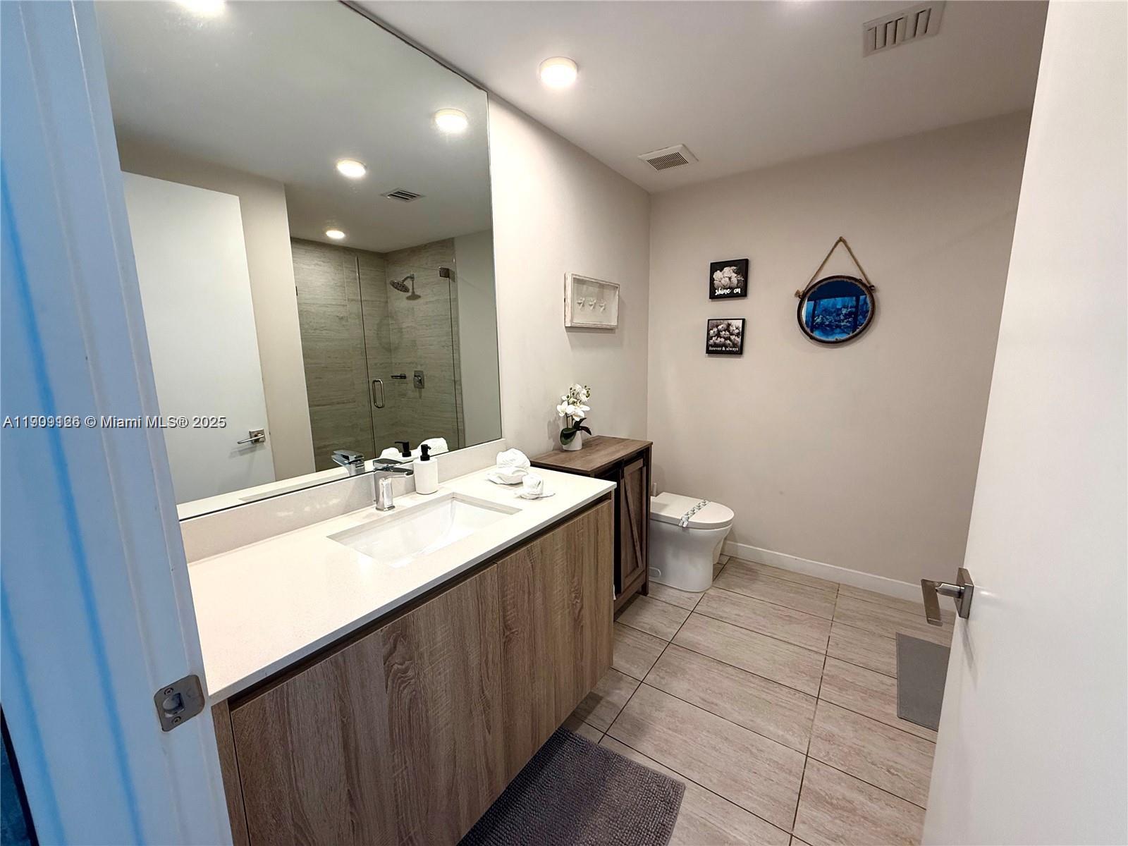 3900 Biscayne Boulevard, Unit N723 Miami, FL 33137 - Photo 13 of 30 a bathroom with a sink and mirror with toilet