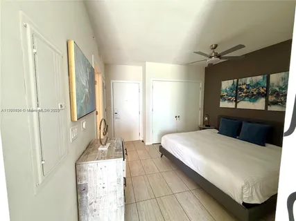 a bedroom with a bed a mirror and a flat tv screen