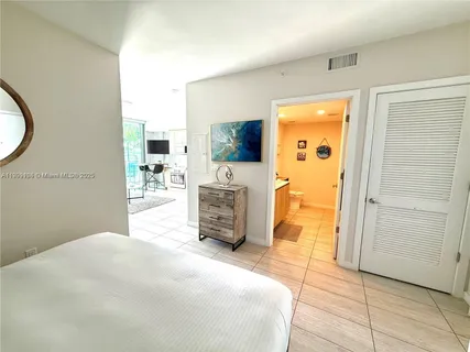 a bedroom with a bed and a flat tv screen