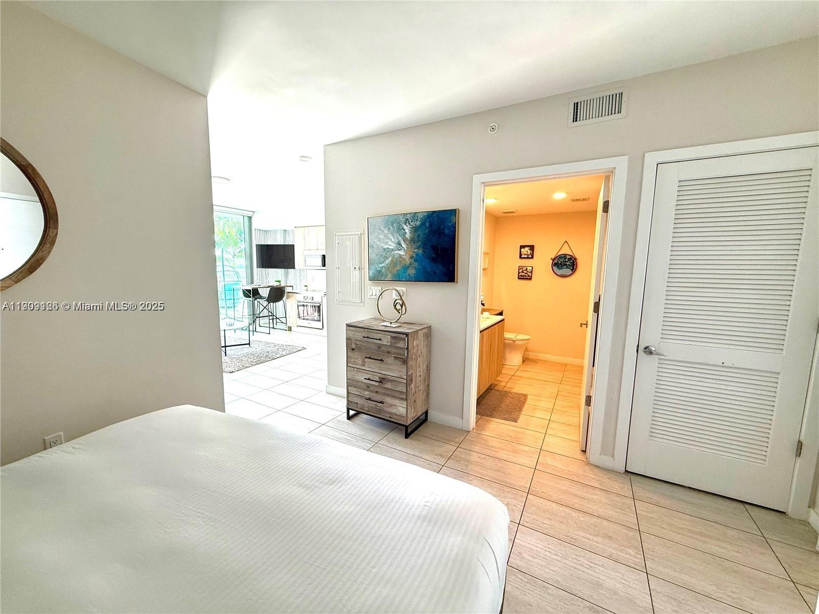 3900 Biscayne Boulevard, Unit N723 Miami, FL 33137 - Photo 18 of 30 a bedroom with a bed and a flat tv screen