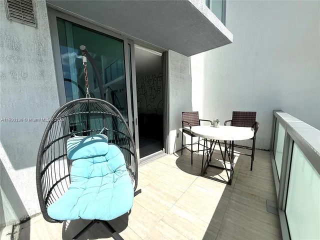 a front view of multi story residential apartment building with yard and outdoor seating