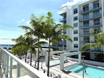 a front view of multi story residential apartment building with yard and outdoor seating