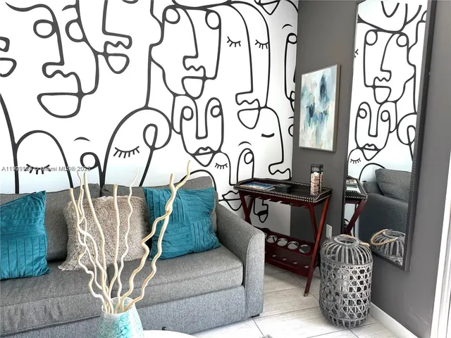 a living room with furniture a flat screen tv and floor to ceiling window