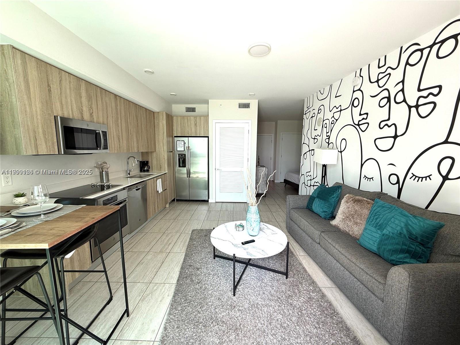 3900 Biscayne Boulevard, Unit N723 Miami, FL 33137 - Photo 7 of 30 a living room with furniture and a flat screen tv