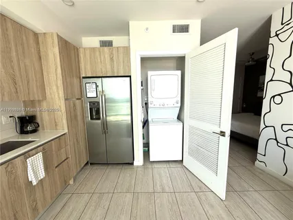 a view of a kitchen with a refrigerator and a stove top oven