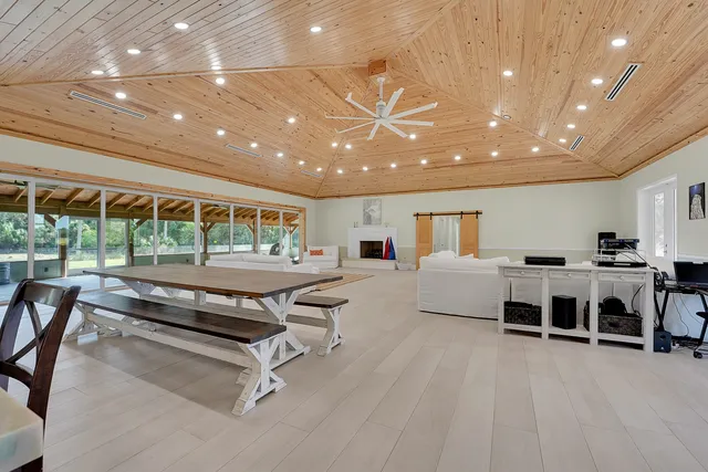 a living room with furniture a large window and white table