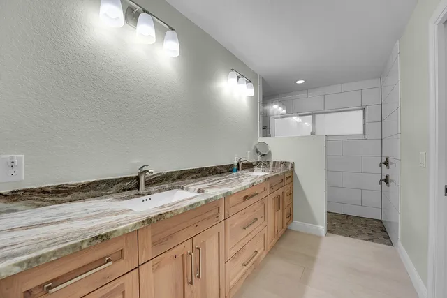 a bathroom with a granite countertop sink a mirror and a